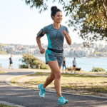 fit woman running in a park, listening to music